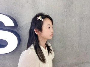 Détail d'un enfant portant une pince à cheveux licorne pailletée avec crinière arc-en-ciel