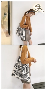 Vista dettagliata della borsa tote in tela stampata chic indossata da una modella