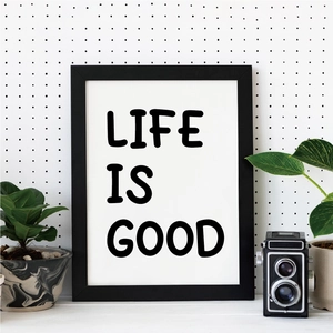 Minimalist black and white wall art with LIFE IS GOOD quote in a modern room setting