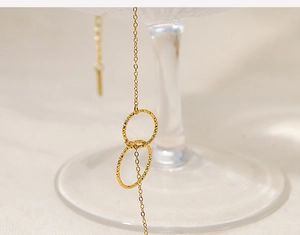 Detailed macro view of gold double interlocking rings necklace with hammered texture