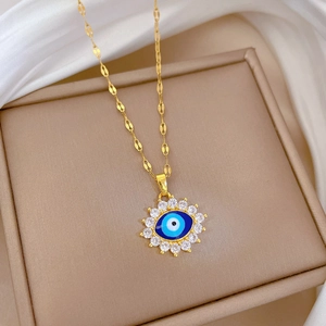Gros plan du pendentif œil maléfique avec cristaux sur une chaîne de collier dorée
