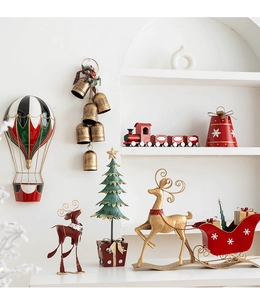 Detail of vintage metal Christmas tree and reindeer sled decorations in red and gold finish