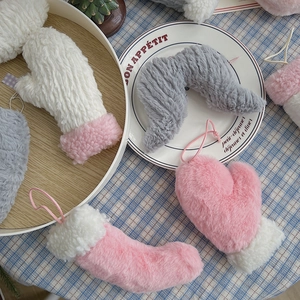 Détail de gants de Noël en peluche roses et blancs sur une assiette décorative