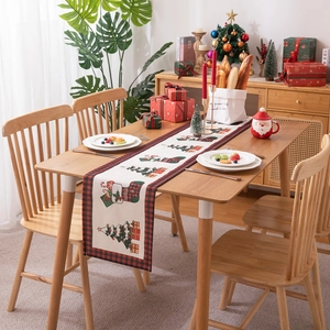 Modern Christmas table runner with festive tree and gift box patterns and plaid edges