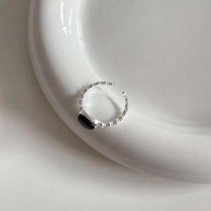 925 sterling silver open ring with black onyx gemstone on a white ceramic plate