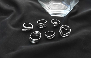 Detailed view of a 6-piece silver vintage ring set with heart and wavy designs on black velvet