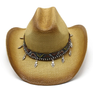 Dettaglio cappello di paglia western con ricami etnici e ciondoli a foglia d'argento