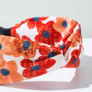 Gros plan détaillé du serre-tête floral orange montrant la texture du tissu et la couture