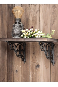 Detail of vintage fleur-de-lis cast iron shelf bracket with rustic black finish