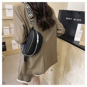 Detail of black crescent crossbody bag with pearl chain and geometric woven strap