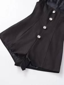 Gros plan du combishort noir avec quatre boutons en strass brillants pour un look élégant