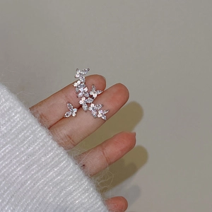 Elegant silver butterfly ear cuff with zircon crystals shown on finger with soft sweater