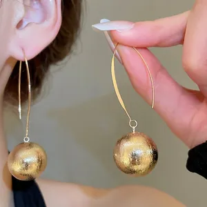 Minimalist golden metallic drop earrings with brushed texture sphere pendants for women