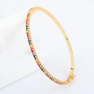 18k gold plated rainbow zircon bangle with oval clasp shown on marble background
