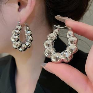 Macro shot of silver-toned hoop earrings featuring a unique bubble texture design