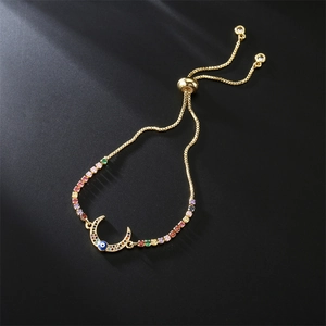 Detail of adjustable gold bracelet with colorful cubic zirconia and evil eye moon charm