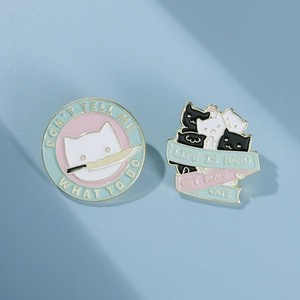 Creative black and white cat enamel pins with humorous quotes on light blue background