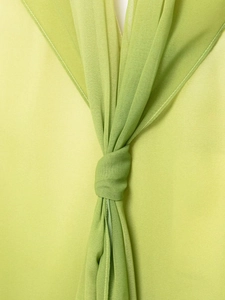Detail view of sheer green chiffon dress with knot design and white stitching trim
