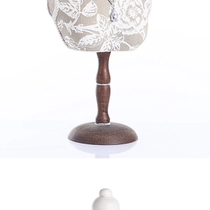 Detail of floral fabric bust necklace stand with solid wood support and round base