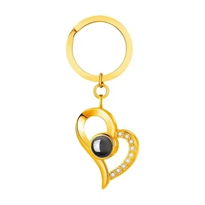 Macro detail of gold-plated heart pendant with embedded projection stone and crystals