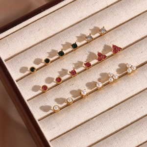 Macro detail of assorted stainless steel pearl and zircon stud earrings set in a velvet box