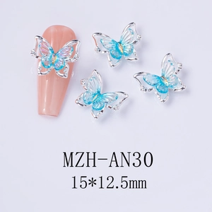 Detailed view of silver laser butterfly nail charms with blue gradient iridescent resin