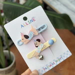 Detail of dog-shaped acrylic hair clips in light blue and yellow with metal heart charms