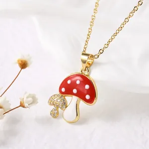 Macro view showing the detailed red mushroom enamel pendant with sparkling cubic zirconia