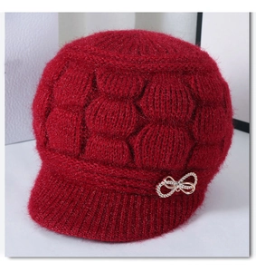 Detailed texture of thick red knit hat for elderly women with crystal butterfly decor