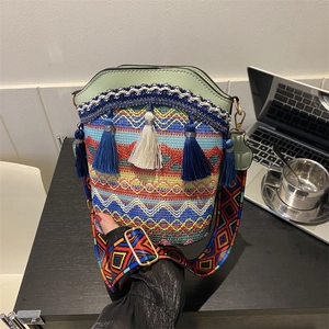 Sac seau ethnique bohème avec motifs tissés colorés, pompons et une large bandoulière