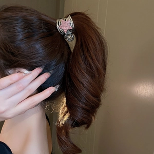 Close-up of Y2K star hair claw with pink rhinestones holding a high ponytail