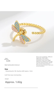 Makroaufnahme von Libellen-Ring mit bunten Zirkonflügeln und Goldbeschichtung