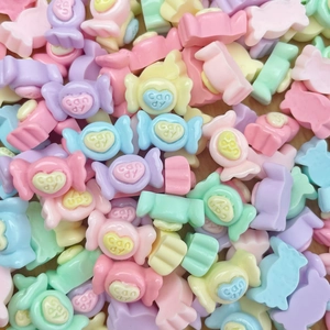 Macro shot of colorful pastel resin candy charms with embossed candy text for DIY crafts