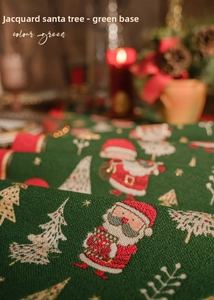Detail of green Christmas table runner with jacquard Santa Claus and tree patterns