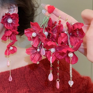 Detail of red fabric flower earrings with crystal tassels and white faux pearl accents