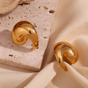 Detailed view of gold plated spiral studs on beige stone and champagne silk texture