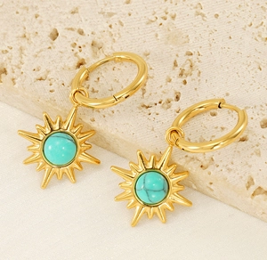 Detail of gold hoop earrings featuring starburst charms with turquoise stone insets