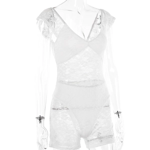 Detail eines weißen Spitzen-Playsuits mit floraler Stickerei und transparentem Stoff