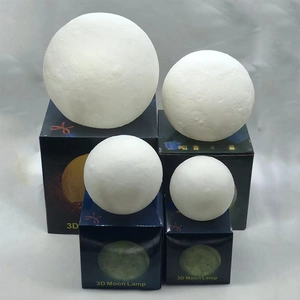 Close-up of four assorted sizes of 3D moon lamps with textured surface on blue box