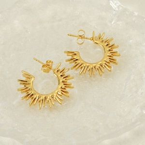 Chic golden fan-shaped sunburst earrings in C-shape design on textured glass tray