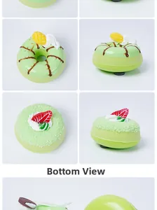 Detailweergaven van een groene donutmagneet met mango- en aardbeidecoraties