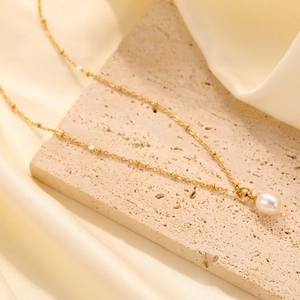Élégant collier en perle dorée avec pendentif goutte sur chaîne fine en acier titane