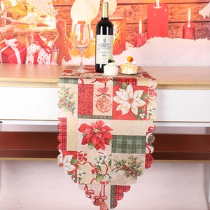 Bord festonné détaillé d'un chemin de table de Noël avec motifs de poinsettia et de houx