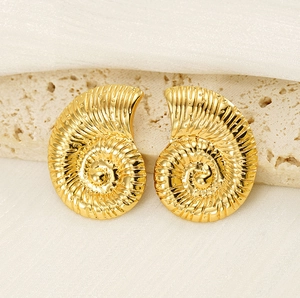 Macro shot of 18K gold-plated nautical spiral shell earrings on a neutral stone display