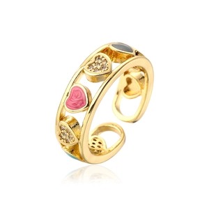 Macro shot of gold-plated open ring with pink enamel hearts and cubic zirconia stones