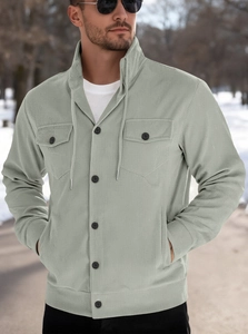 Macro shot of men's sage green corduroy jacket fabric texture and buttoned chest pocket