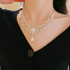 Nahaufnahme der royalen Tropfenperlenkette mit Strass und hohlem Vintage-Anhänger