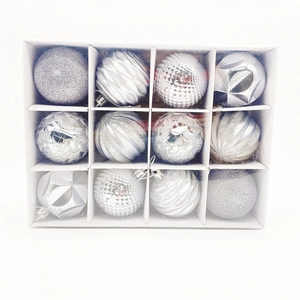 Detail of 12 silver and white Christmas baubles with glitter and embossed patterns in a box