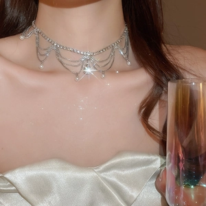 Close-up of elegant silver choker with layered rhinestone tassels and pearl drops on model