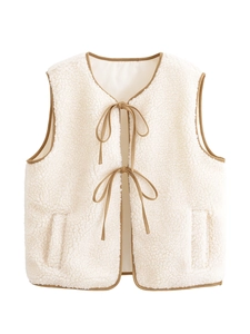 Detail of faux shearling vest with contrast brown trim and bow tie closures
